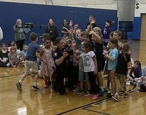 Group of kids huddling around police officers