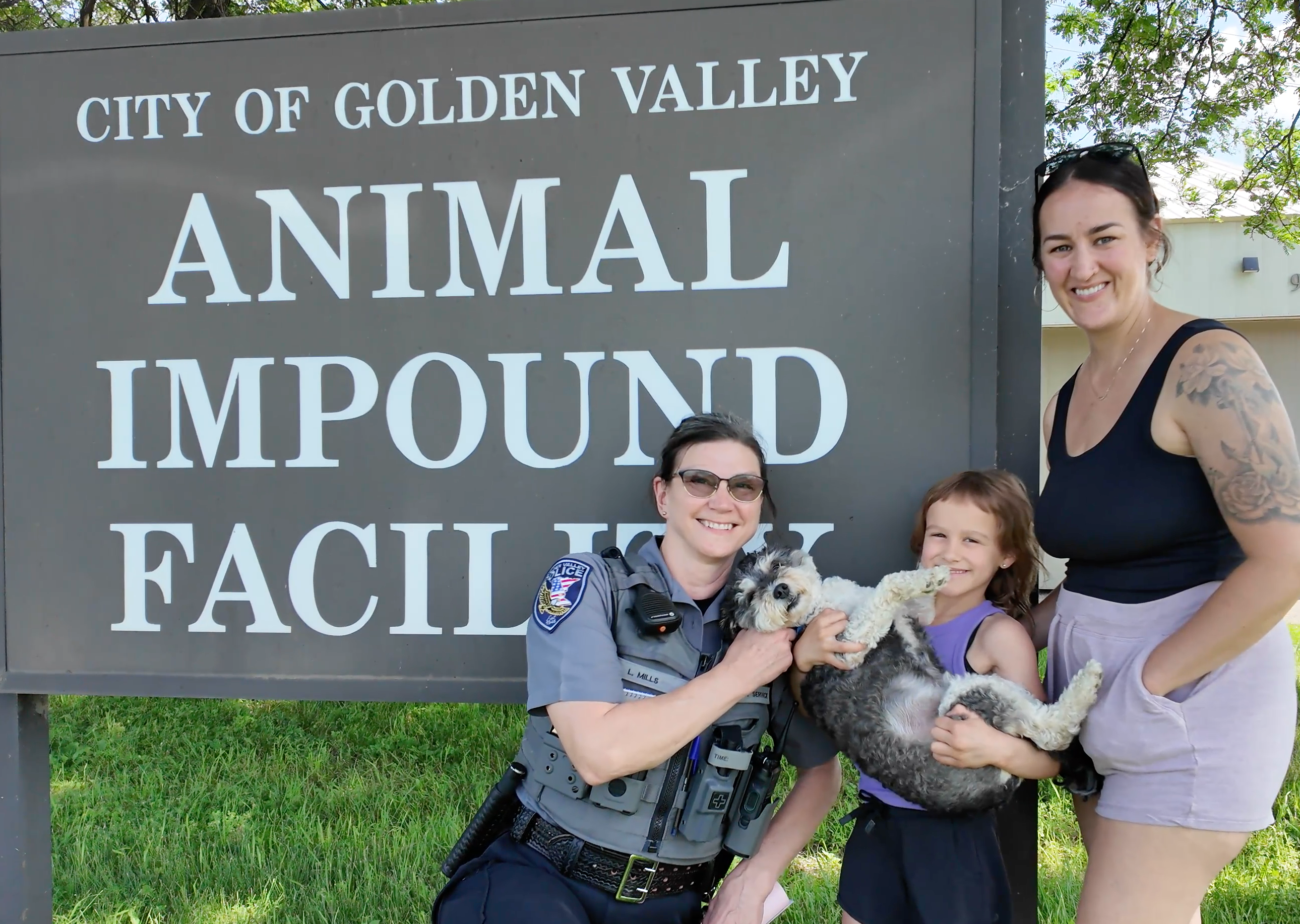 Officer and family taking a photo with a reunited lost dog