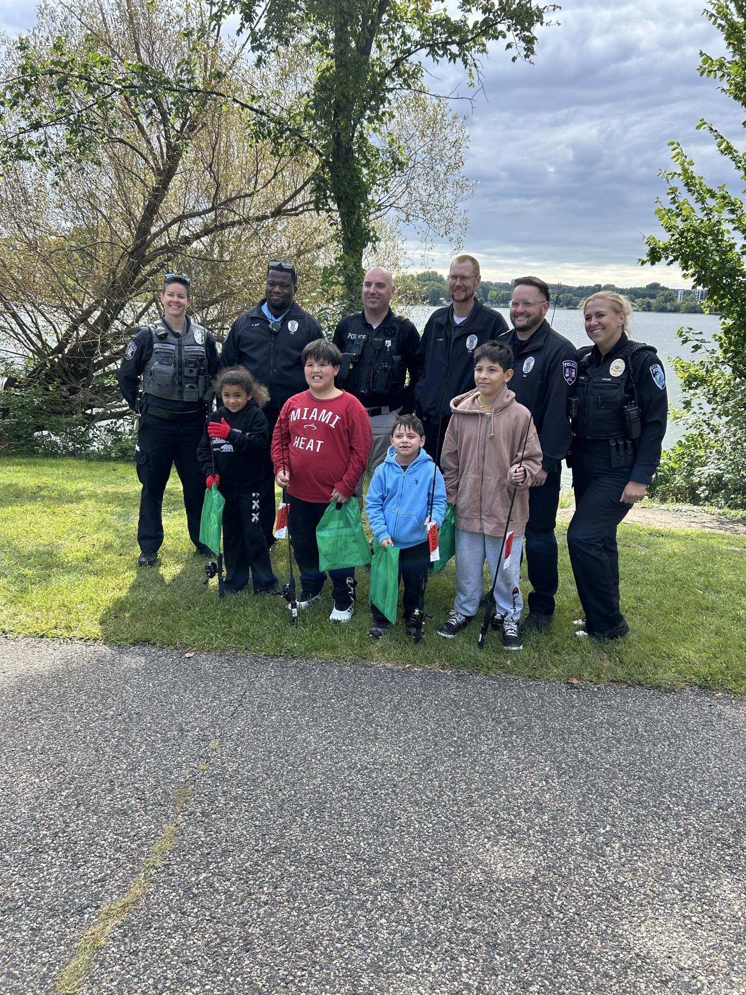 Law enforcement staff from the local police departments pose with kids for the Badges & Bobbers even
